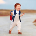 Child wearing dinosaur harness backpack outdoors