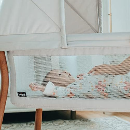 Lightweight newborn bassinet with mesh side panels showing waterproof mattress