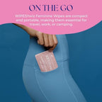 Compact travel size feminine hygiene wipes being placed into a small handbag.