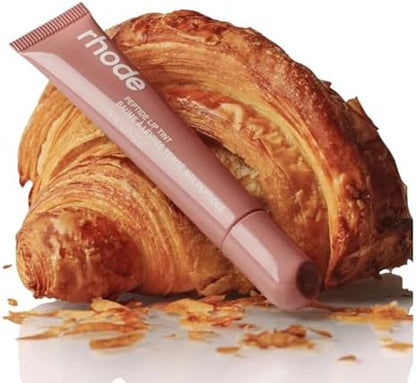 Hydrating peptide lip treatment tube being held to showcase the Toast shade label.