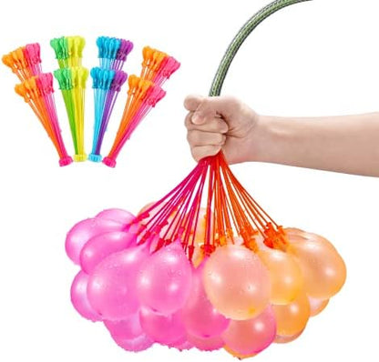 Bright multi colored tropical theme water balloons resting inside a water filled bucket prepared for outdoor play.
