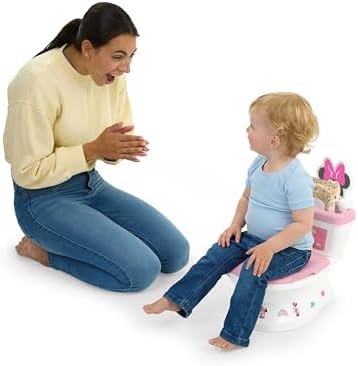 Toddler using Bright Starts Minnie Mouse potty seat on adult toilet