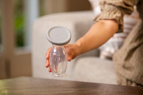 Haakaa manual breast pump with suction base secured on a flat tabletop.