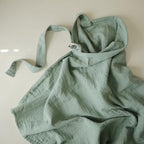 Parent using Mushie organic muslin nursing cover for privacy