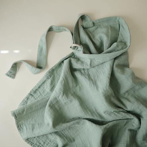 Parent using Mushie organic muslin nursing cover for privacy