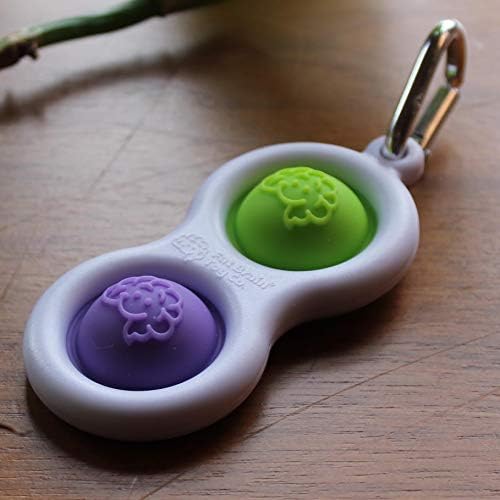 Hand holding the imported Purple and Lime simple dimple toy to demonstrate its portable size.