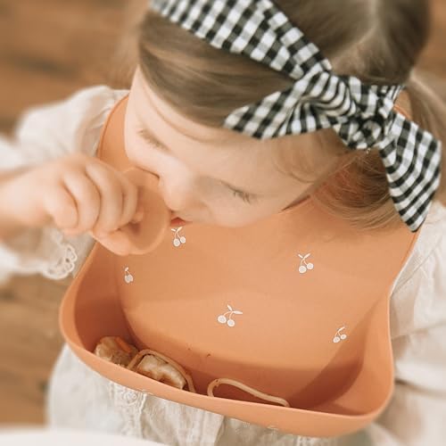 Close up view of the reinforced buttonholes on the Moonkie silicone baby bib neckband