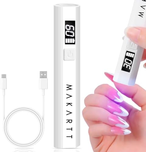 Portable mini cordless flash cure nail lamp being held to dry individual nail extension art.