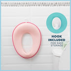 Pink portable kids potty seat hanging on the included storage hook