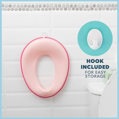 Pink portable kids potty seat hanging on the included storage hook
