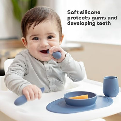 The two sage green baby weaning utensils resting on a highchair tray.