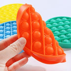 Portable washable silicone sensory tool being pressed by adult fingers for focus enhancement.