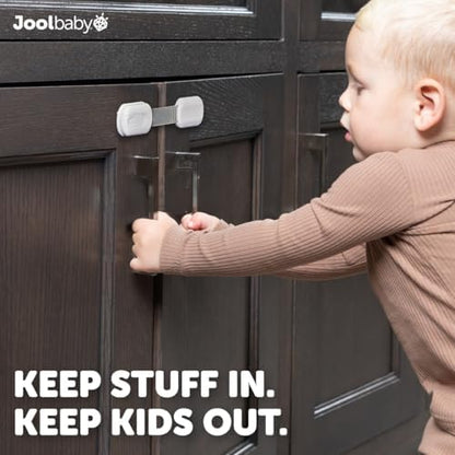 Adjustable baby safety strap locks installed on a white kitchen cabinet corner
