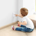 Clear childproof light switch cover installed on a wall