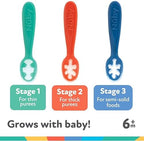 Flexible food grade silicone baby spoons being held to demonstrate the soft material