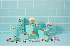 Miniature food replicas and decorative magnets arranged neatly on the toy refrigerator shelves