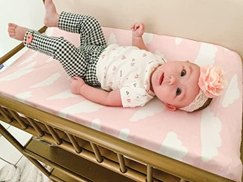 Pure cotton pink and white cloud patterned diaper changing table sheet stretched on a contoured pad.