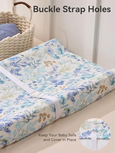 Detailed shot of the safety strap holes on the cotton floral diaper changing surface.