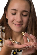 Magician performing coin vanish trick with brass props