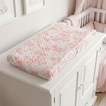 Pink bow and floral changing pad sheets on changing table