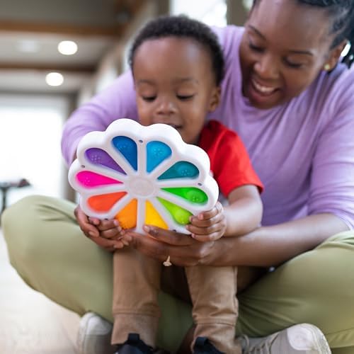 Toddler hands pushing the colorful sensory silicone buttons to develop fine motor skills.