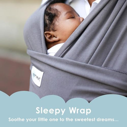 Infant tucked inside a dark gray Sleepy Wrap baby carrier showing ergonomic M leg position