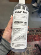 Applying Lice Queen spray to child's hair for school protection
