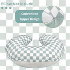 Reversible green checkered nursing pillow cover folded on a nursery chair
