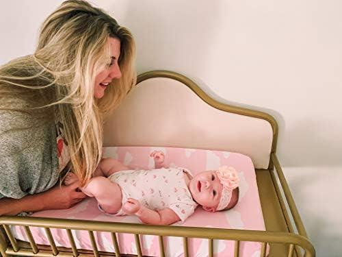 Demonstration of the stretchable fabric fitting smoothly over a standard infant diaper changing mattress.