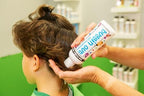 Buggin Out dimethicone oil bottle placed next to a lice removal comb