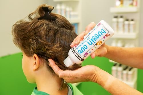 Buggin Out dimethicone oil bottle placed next to a lice removal comb