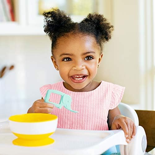 Infant holding the mint colored animal teether spoon demonstrating easy grip design.