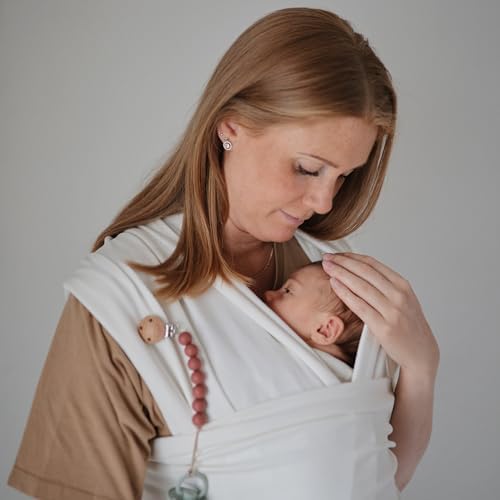 Mushie baby wrap carrier neatly folded inside its built in storage pocket