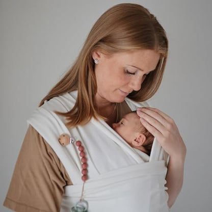 Mushie baby wrap carrier neatly folded inside its built in storage pocket