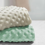 Nivava Baby changing table sheet folded in sand and green colors.