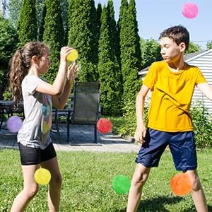 Family playing with eco-friendly reusable water balloons during a summer backyard lawn party.