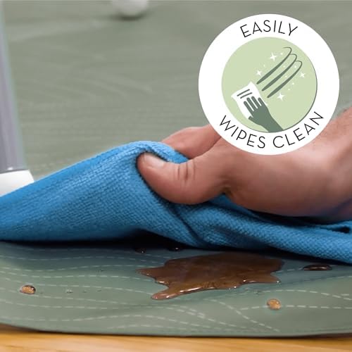 Folded S&T INC. water resistant splash mat being placed inside a diaper bag.