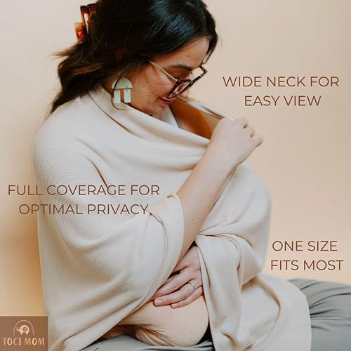 Mother using Toci Mom nursing poncho for discreet public breastfeeding