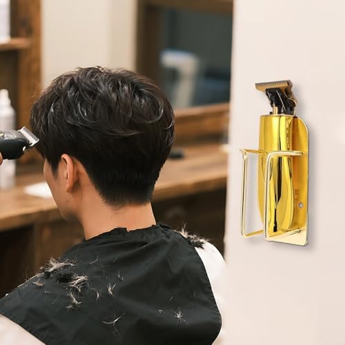 Gold finished metal trimmer storage stand mounted on salon wall holding electric hair clippers securely