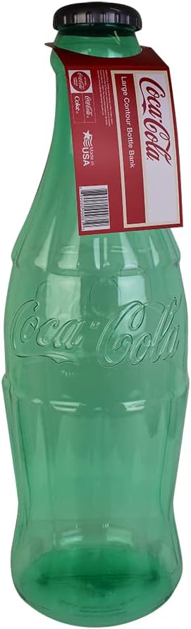 The collectible twenty-two inch tall clear Coca-Cola coin bank styled as home decor on a wooden desk.