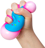 A person holding the squishy Schylling donut toy at an office desk for anxiety management.
