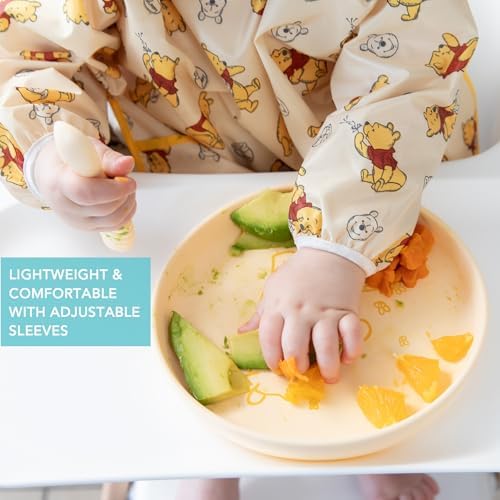 Bumkins Disney baby bib demonstrating the elasticized cuffs for adjustable sleeve length