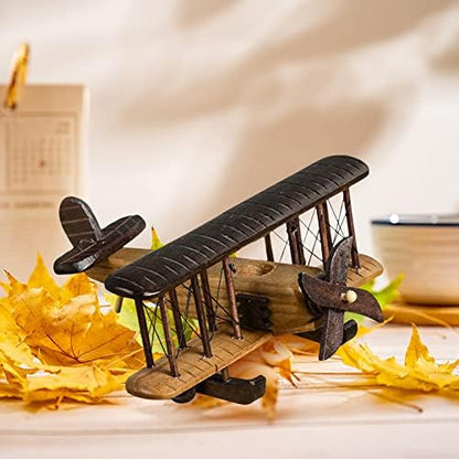 Retro aircraft glider biplane wooden ornament displayed on an office desk setup.
