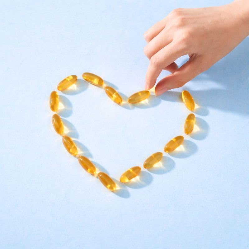 Golden yellow translucent Trumax omega 3 softgel capsules arranged on a white surface