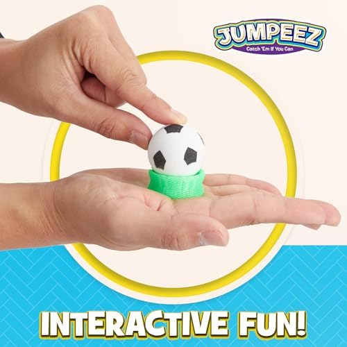 A child hand pressing down on a rubber jumping popper toy on a flat surface