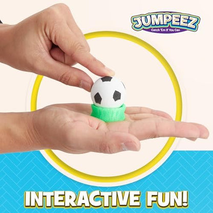 A child hand pressing down on a rubber jumping popper toy on a flat surface