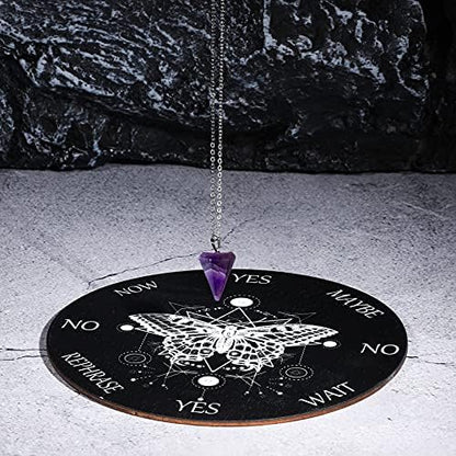 Hand holding crystal pendulum over wooden butterfly board