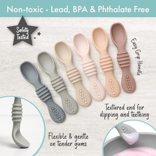 Infant holding a PrimaStella neutral color silicone feeding spoon practicing self feeding
