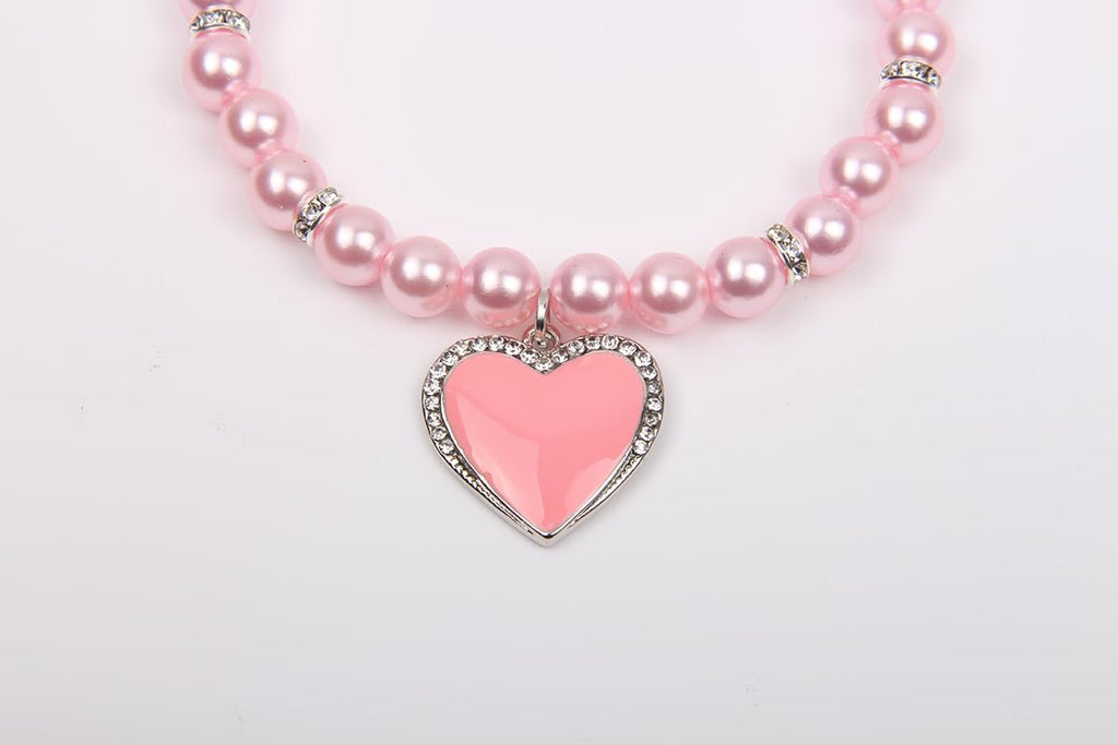 Elegant pink pet necklace laid flat showcasing the premium materials.