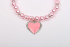 Elegant pink pet necklace laid flat showcasing the premium materials.